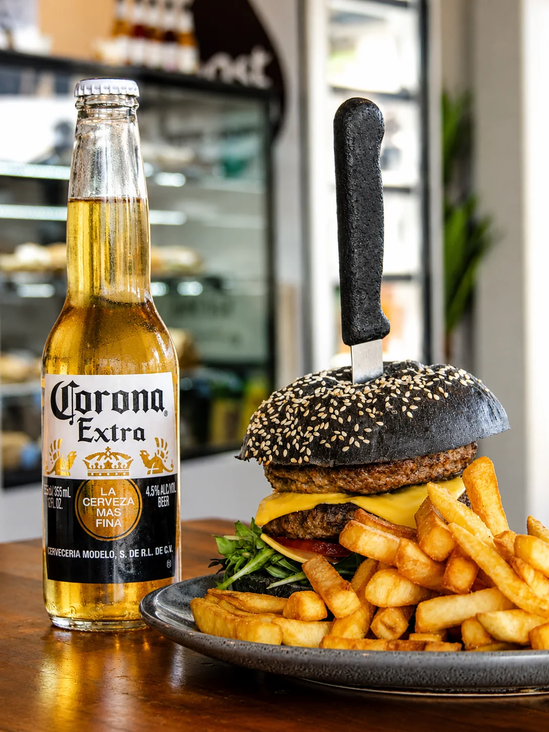 A double burger with fries and a chilled bottled drink