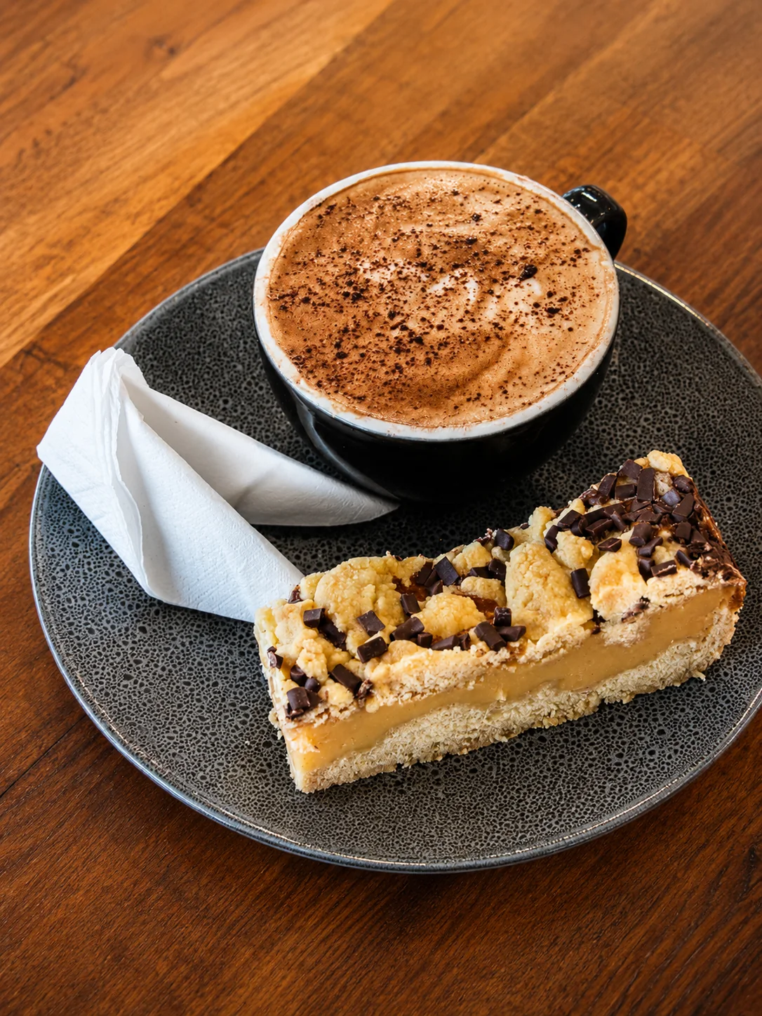 A hot coffee served with a café slice